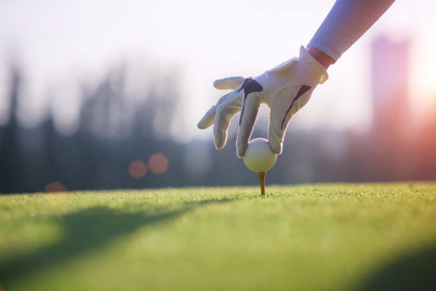 Golfball wird auf einen Pin gesetzt